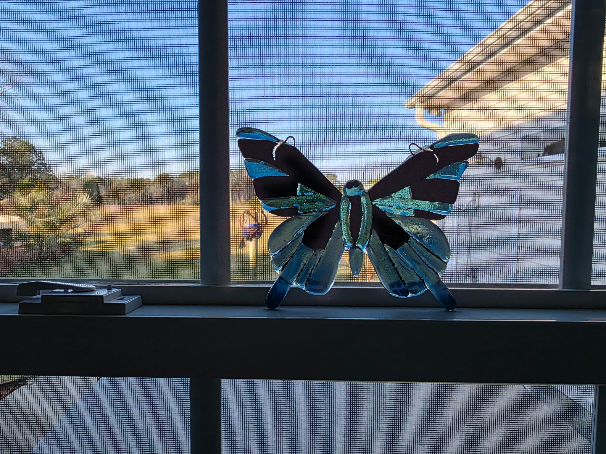 Butterfly-shaped fused glass wall panel in teal and dark brown