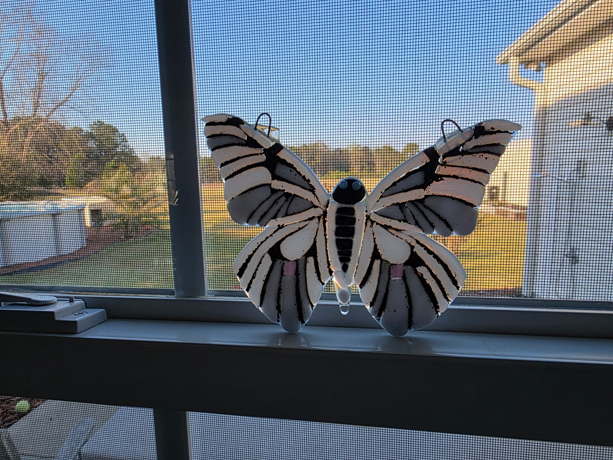 White and black fused glass butterfly suncatcher with bold striped pattern