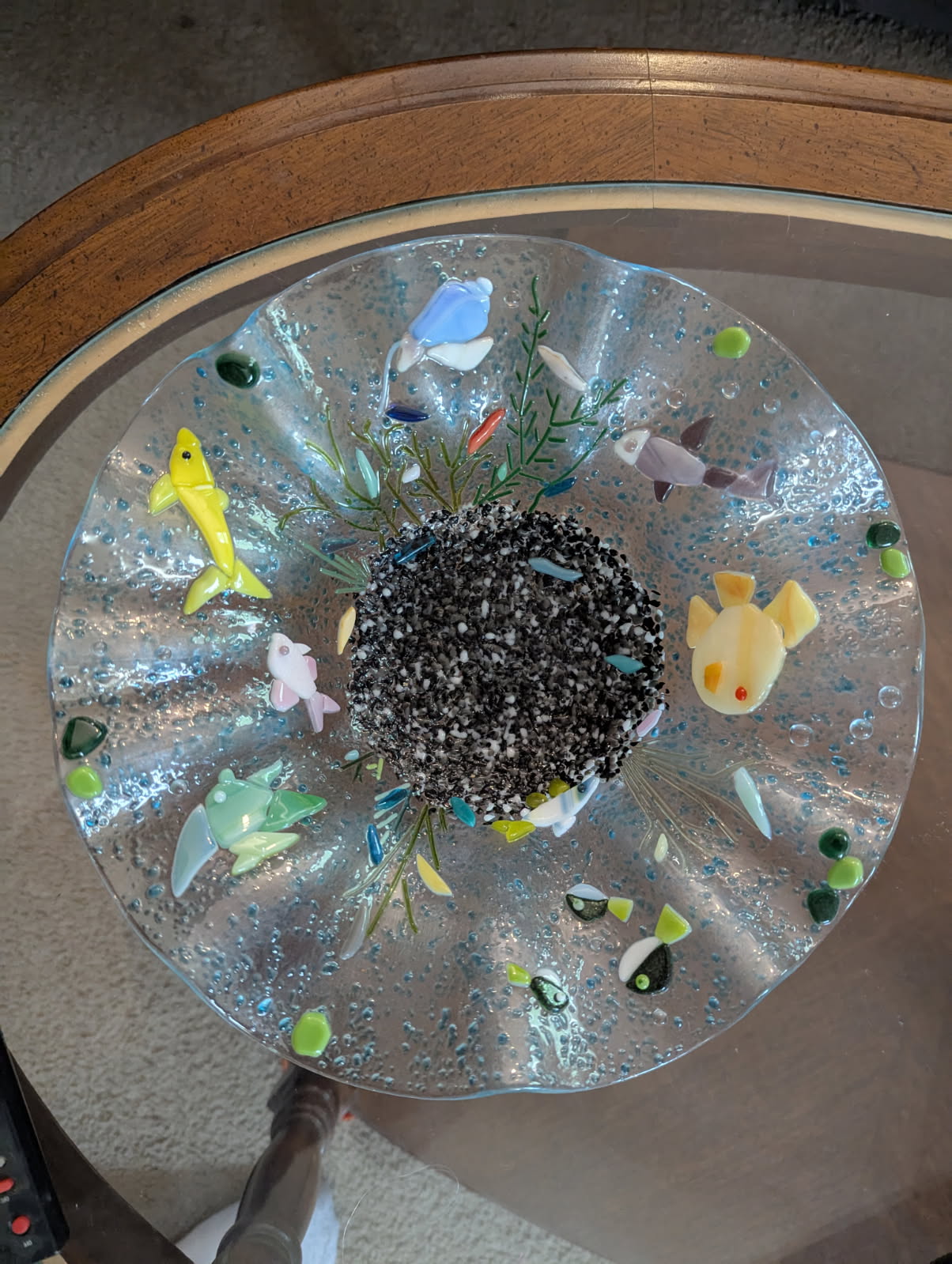 Shallow fused glass dish with colorful fish in yellow, pink, and green