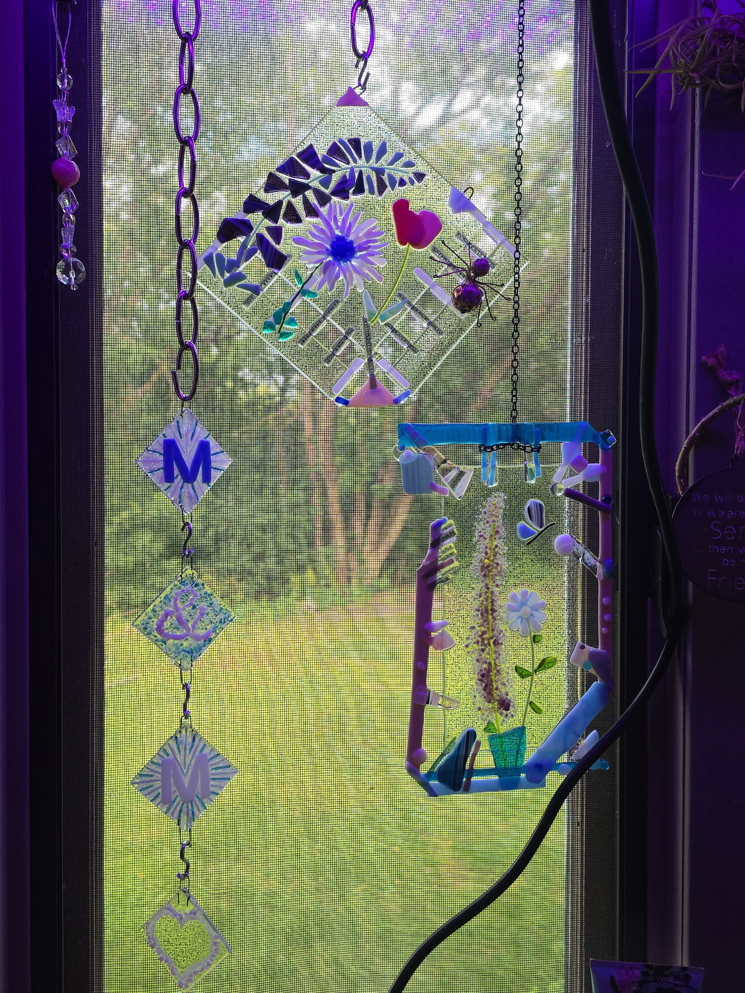 Diamond-shaped fused glass suncatcher with floral and heart pattern in purple, blue, green, and pink